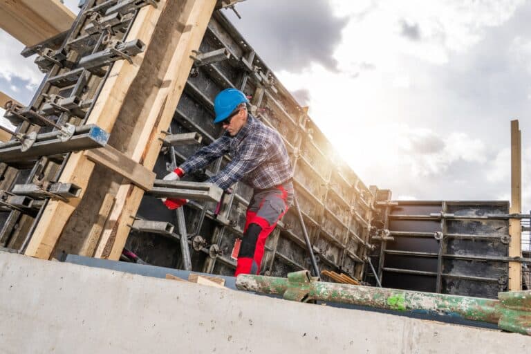 Ouvrier du bâtiment fabriquant un coffrage en béton sur le chantier.