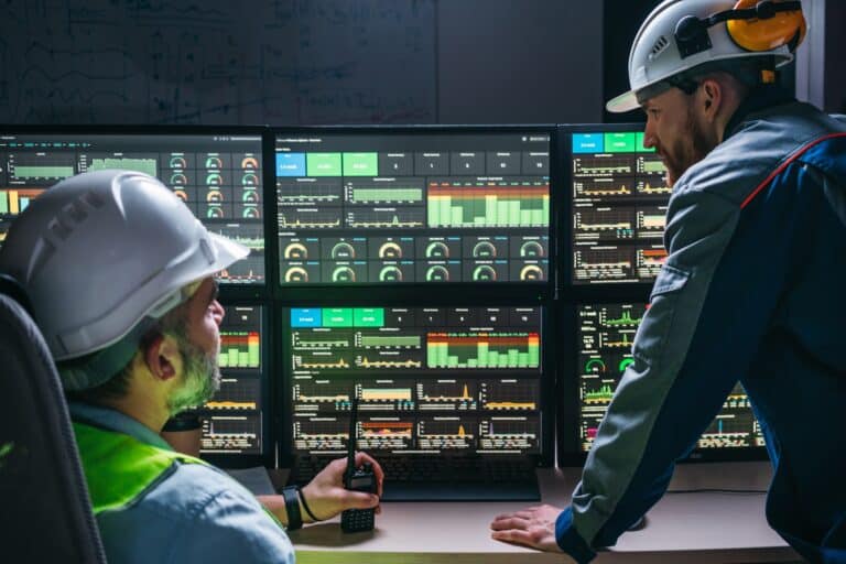 Deux opérateurs contrôlent le processus sur une ligne de production utilisant l’Industrie 4.0 et les technologies numériques dans une usine moderne. Deux ingénieurs suivent le processus d’assemblage grâce au système SCADA, une technologie de pointe.